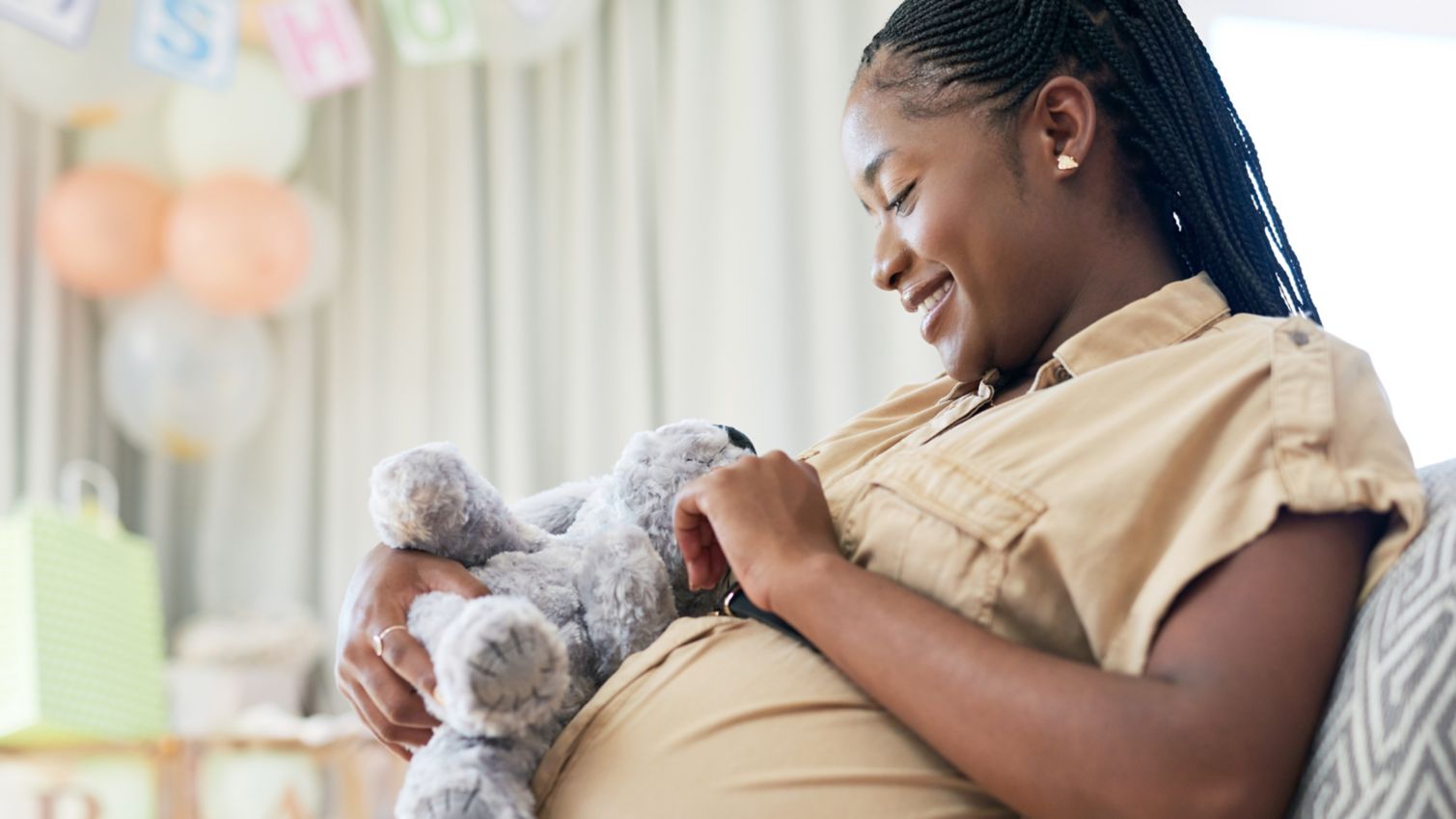 Pregnant mom holds stuffed animal at baby shower